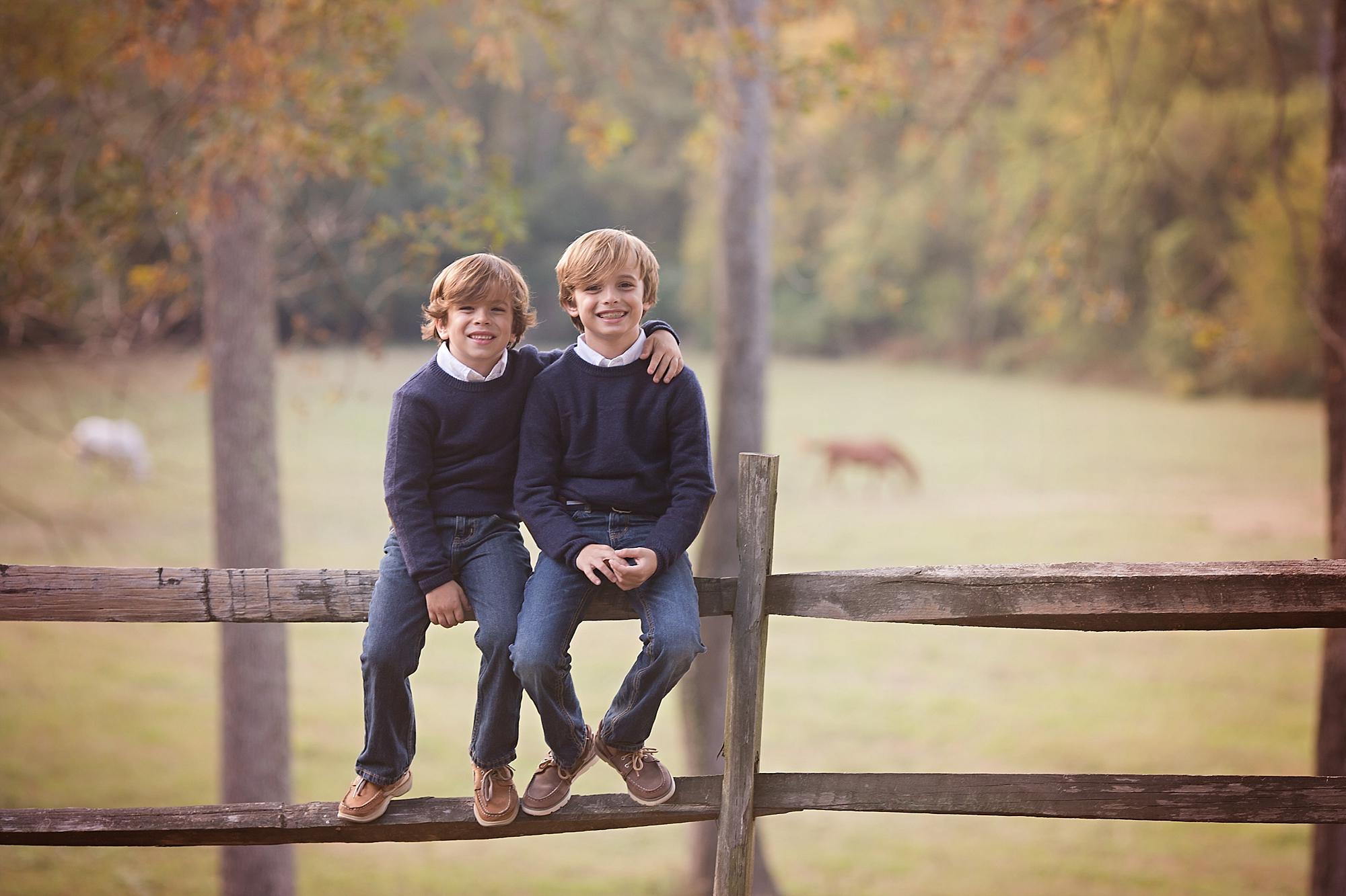 brothers sitting on a fence