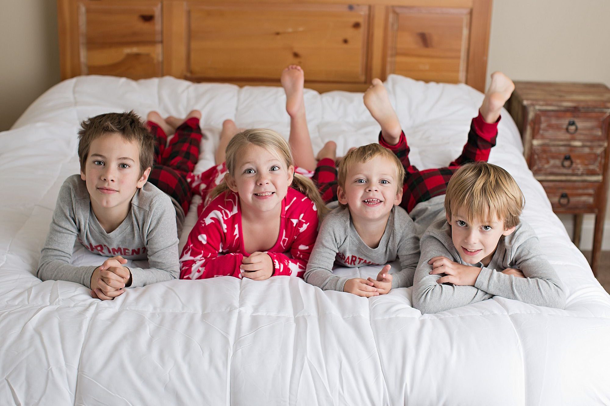 four kids on a bed in christmas pjs